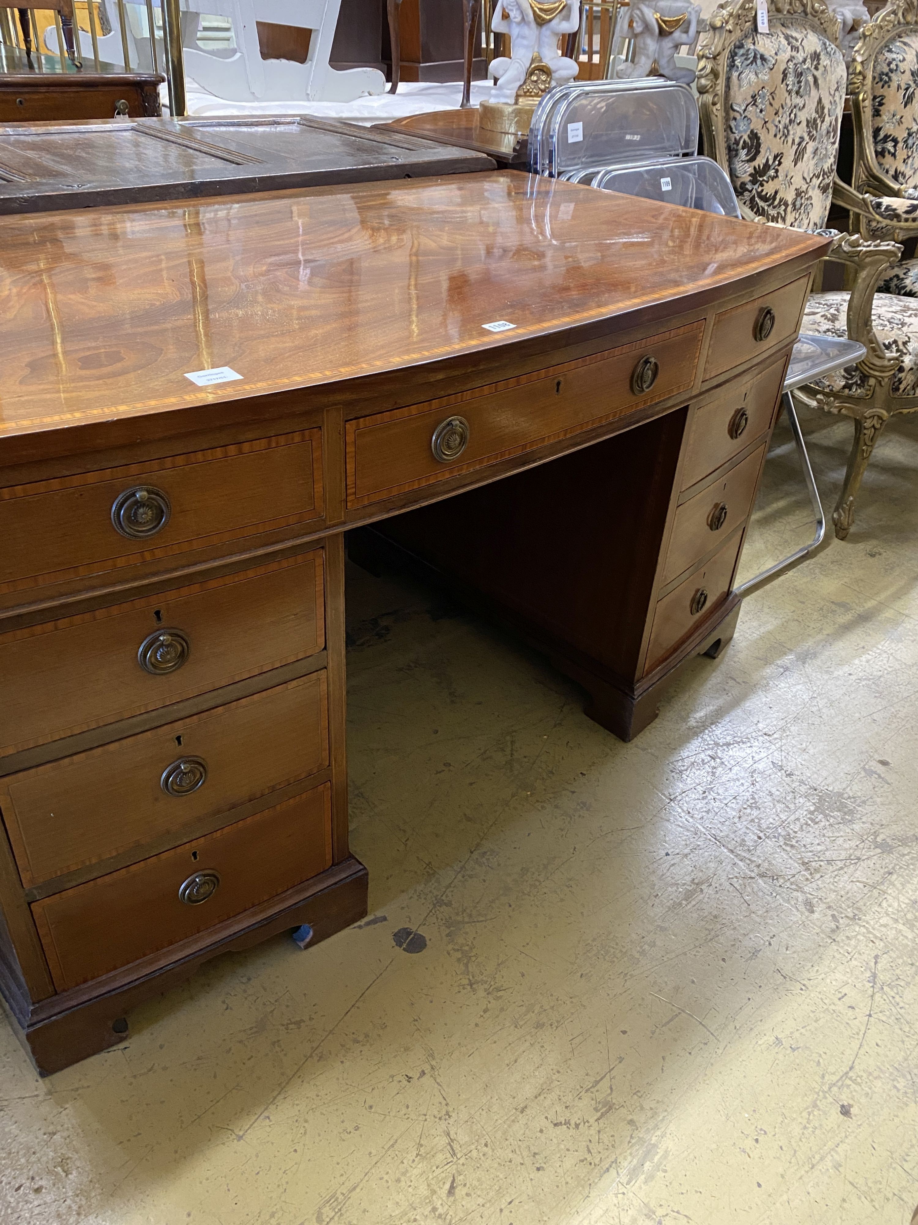An Edwardian satinwood banded mahogany bow front kneehole pedestal desk, width 137cm, depth 76cm, height 74cm